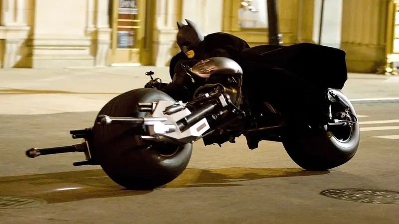 Batman rides the Batpod through a Gotham City street in The Dark Knight (2008)